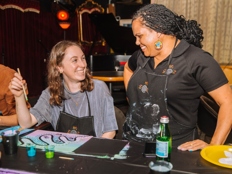 Two women smiling in a Bristol painting class